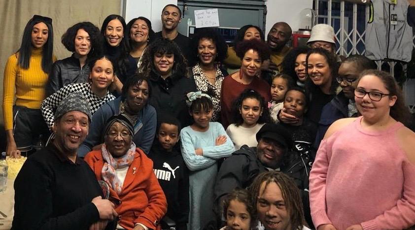Cynthia surrounded by her family, smiling together at a gathering.
